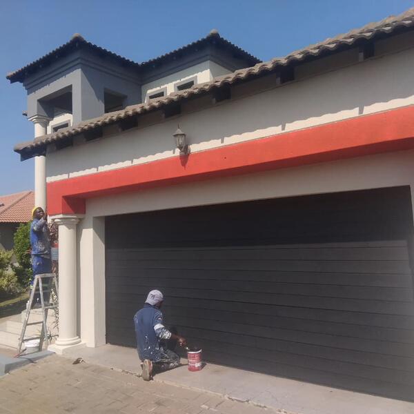Double-Storey Exterior Restoration - Painting the garage door and red trim band