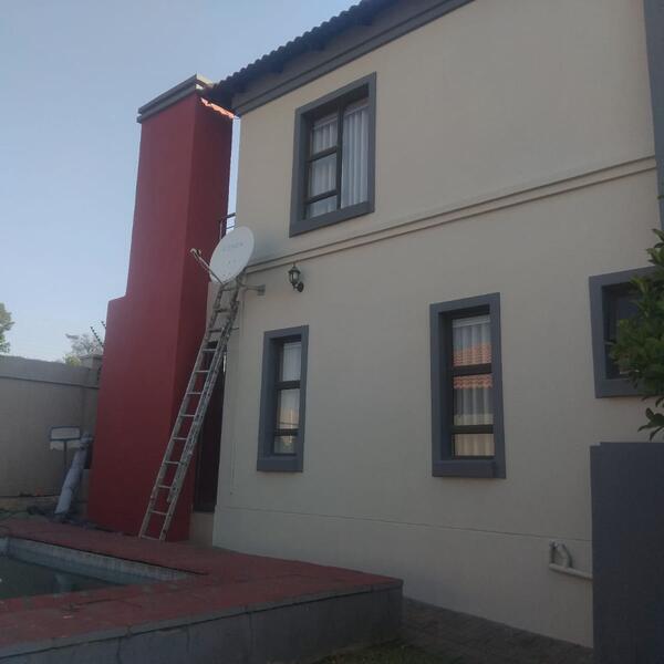 Double-Storey Exterior Restoration - Completed side elevation with red chimney feature