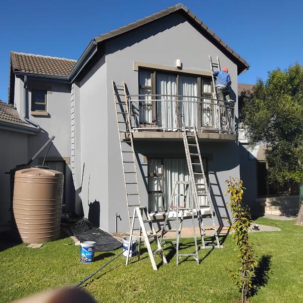 Modern Home Exterior Makeover - First coats of grey going on